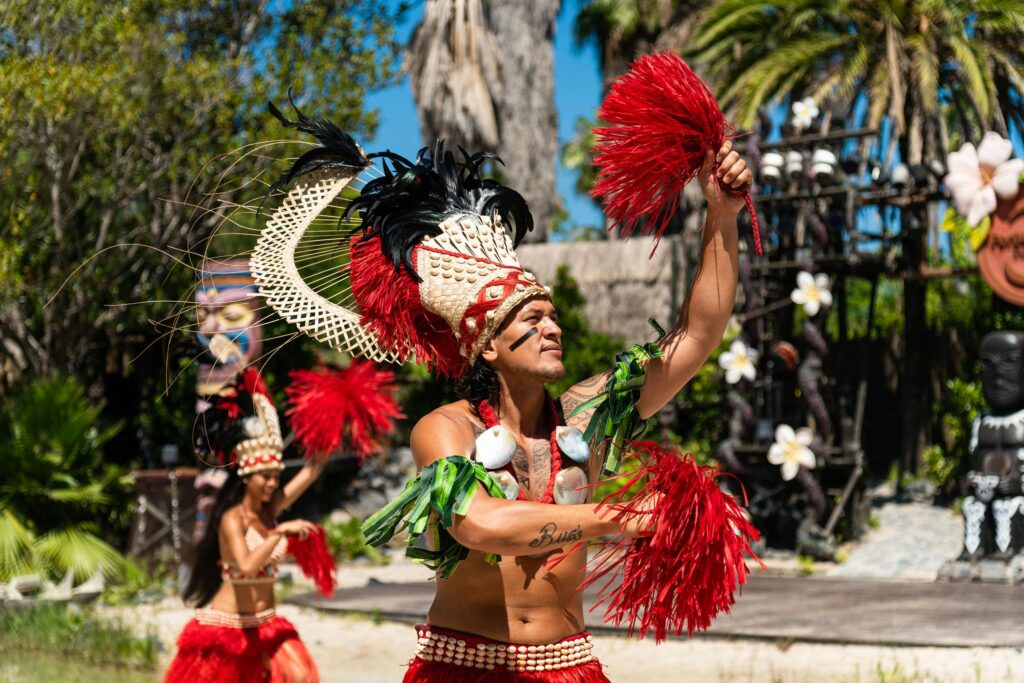 Vibrant Polynesian dancers perform a traditional dance in colorful costumes outdoors.